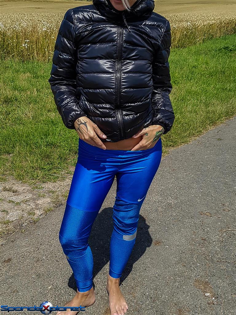 Black downjacket and shiny blue Nike leggings 